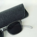 Klammeraffe No.11 bifocal reading sunglasses in cloud color with longer temples together with the case on a gray underground.