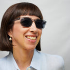 Klammeraffe No.11 bifocal reading sunglasses in cloud color with longer temples, worn by a woman on a white background.