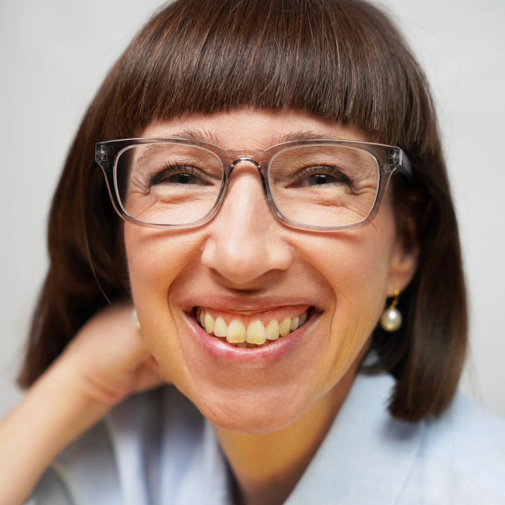 Klammeraffe No.11 blue light glasses in cloud color with longer temples, worn by a woman on a white background.