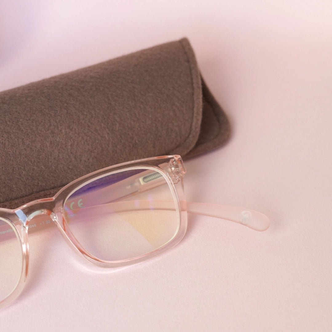 Klammeraffe No.11 blue light reading glasses in rosé color with longer temples together with the case on a pink underground.