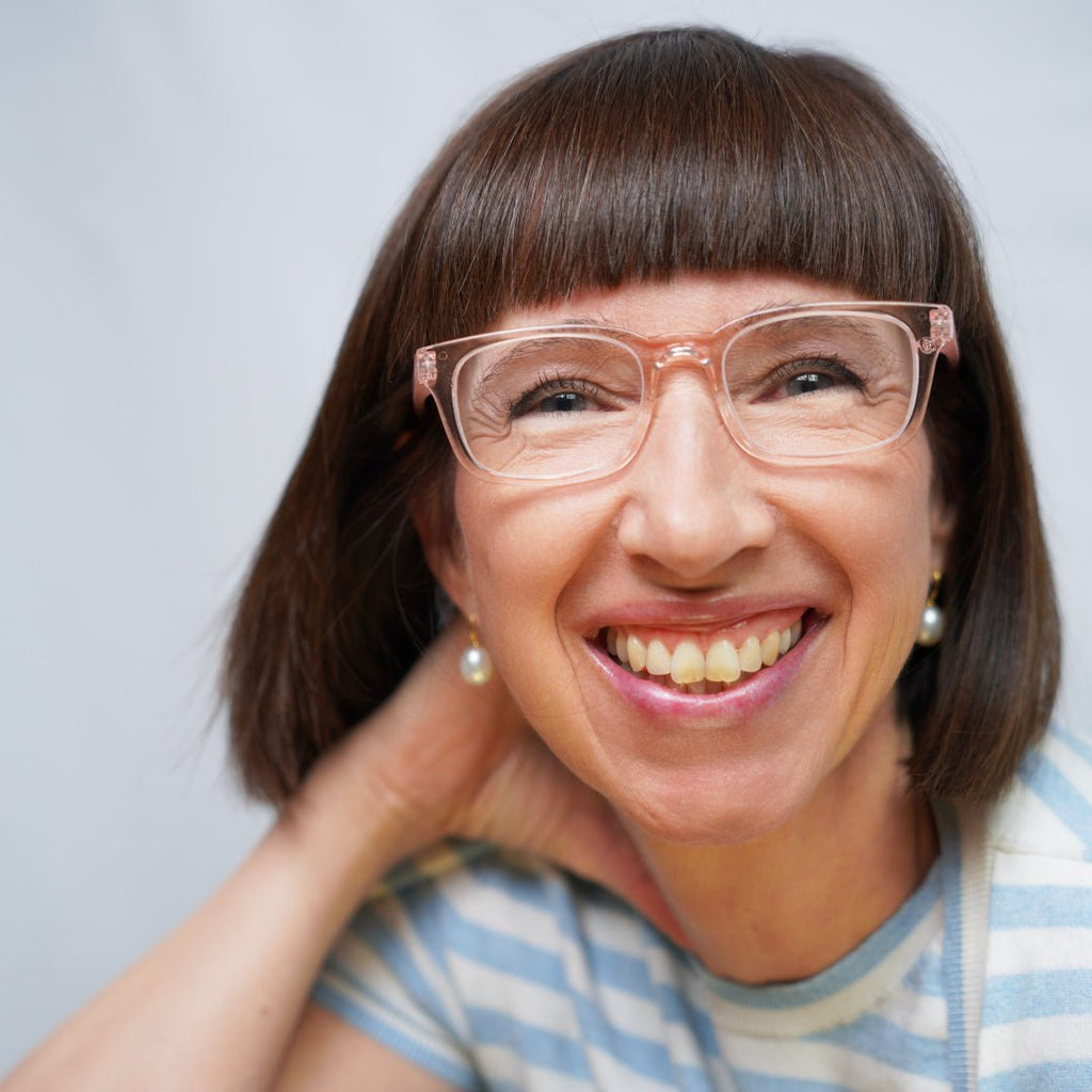 Klammeraffe No.11 blue light glasses in pearl rosé color with longer temples, worn by a woman on a white background.