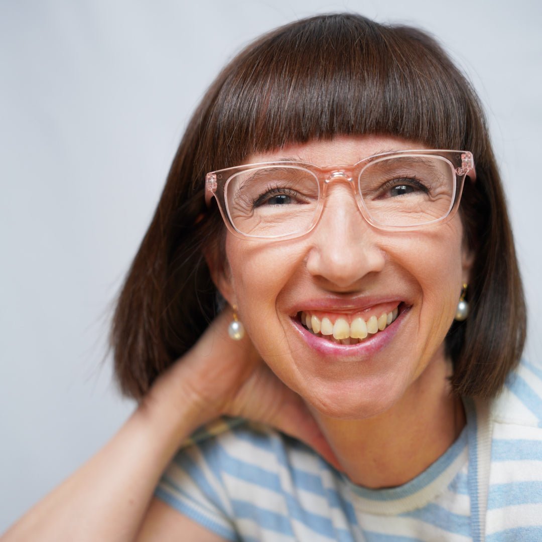 Klammeraffe No.11 blue light glasses in pearl rosé color with longer temples, worn by a woman on a white background.