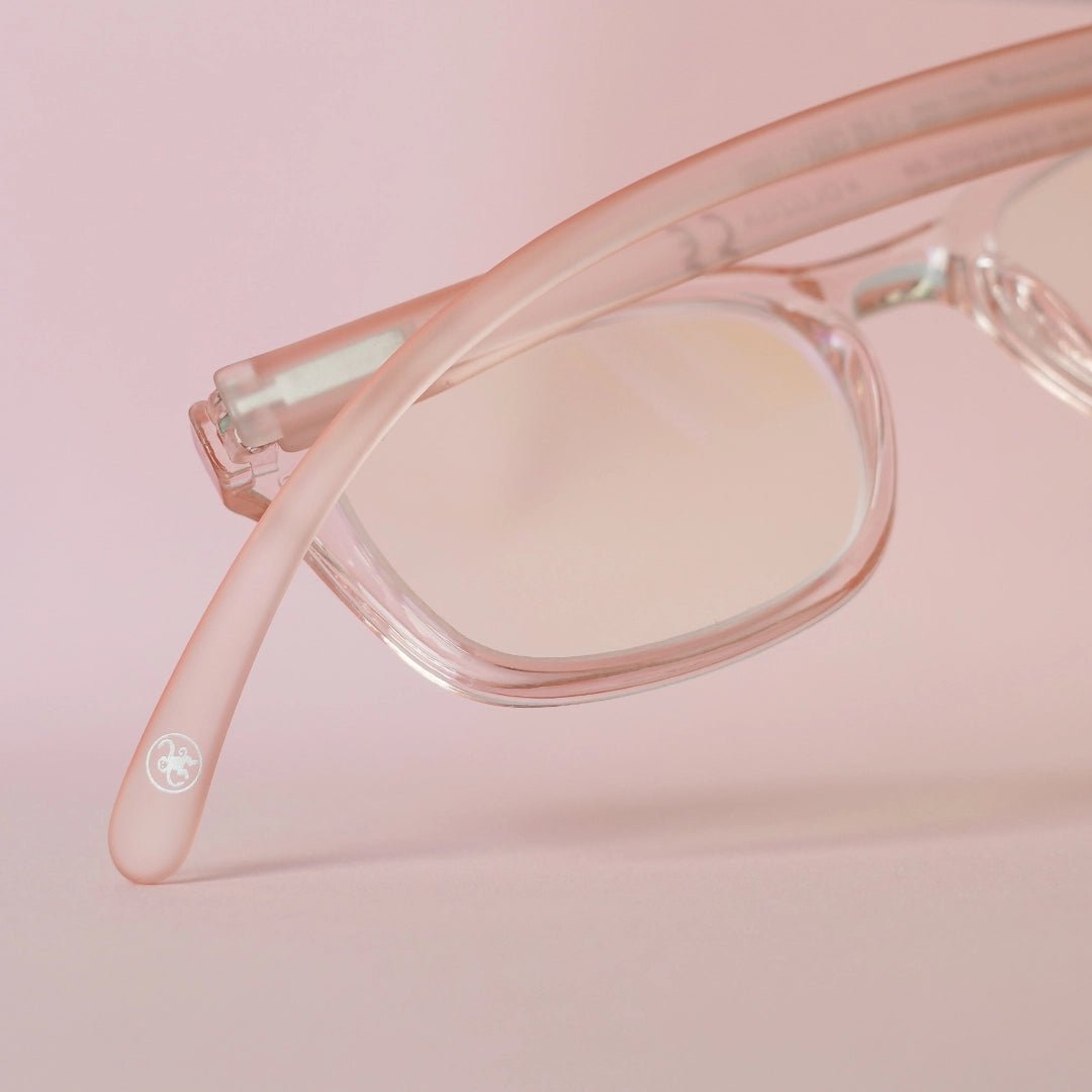 Klammeraffe No.11 blue light reading glasses in pearl rosé with longer temples from the backside on a pink background.