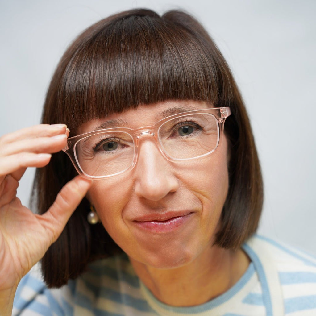 Klammeraffe No.11 blue light reading glasses in pearl rosé color with longer temples, worn by a woman on a white background.