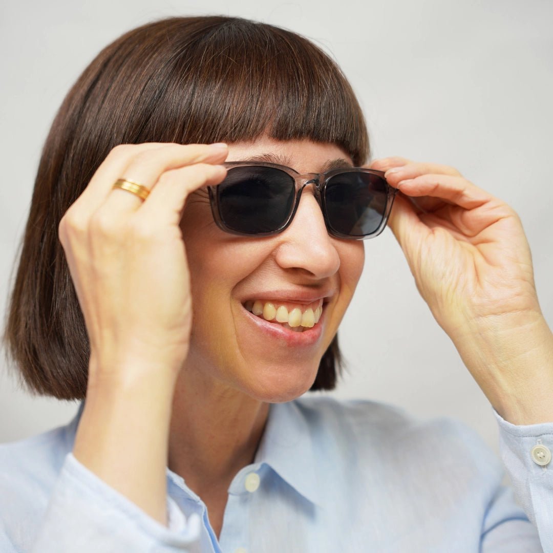 Klammeraffe No.01 reading sunglasses in cloud color with longer temples, worn by a woman on a white background.