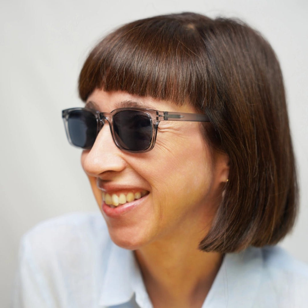 Klammeraffe No.11 sunglasses in cloud color with longer temples, worn by a woman on a white background.