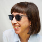 Klammeraffe No.11 sunglasses in cloud color with longer temples, worn by a woman on a white background.