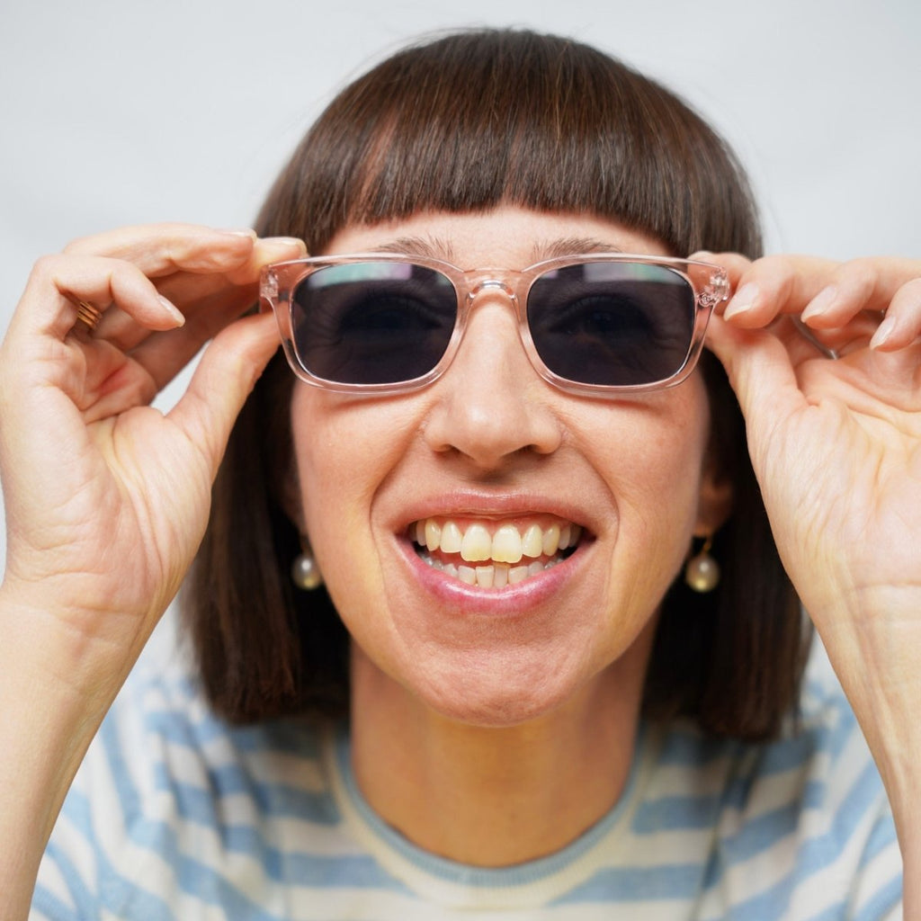 Klammeraffe No.11 sunglasses in pearl rosé color with longer temples, worn by a woman on a white background.