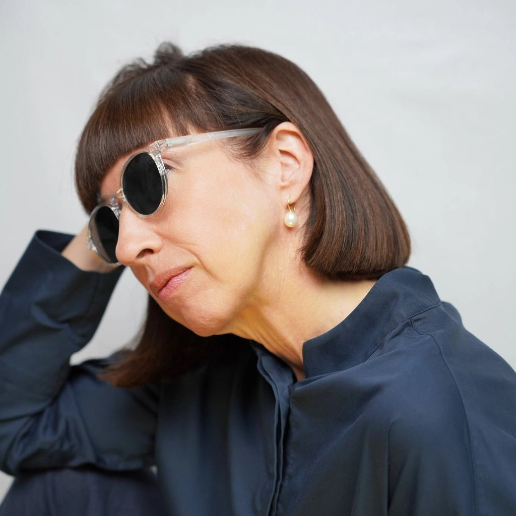 Klammeraffe No.12 bifocal reading sunglasses in crystal color with longer temples, worn by a woman on a white background.