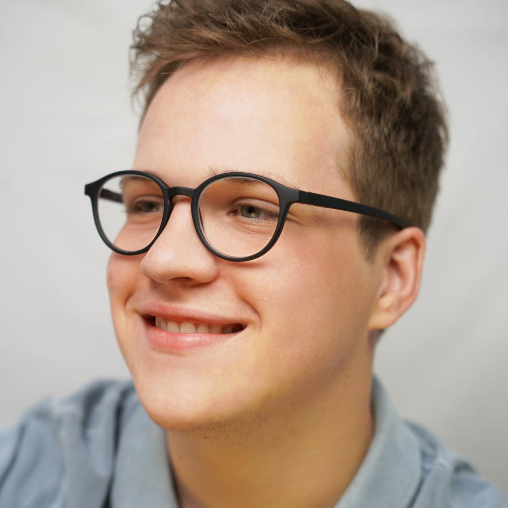 Klammeraffe No.12 blue light glasses in black color with longer temples, worn by a man on a white background.