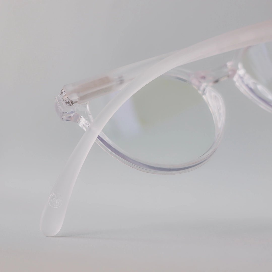 Klammeraffe No.12 blue light glasses in crystal with longer temples from the backside on a gray background.