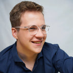 Klammeraffe No.12 blue light glasses in crystal color with longer temples, worn by a man on a white background.