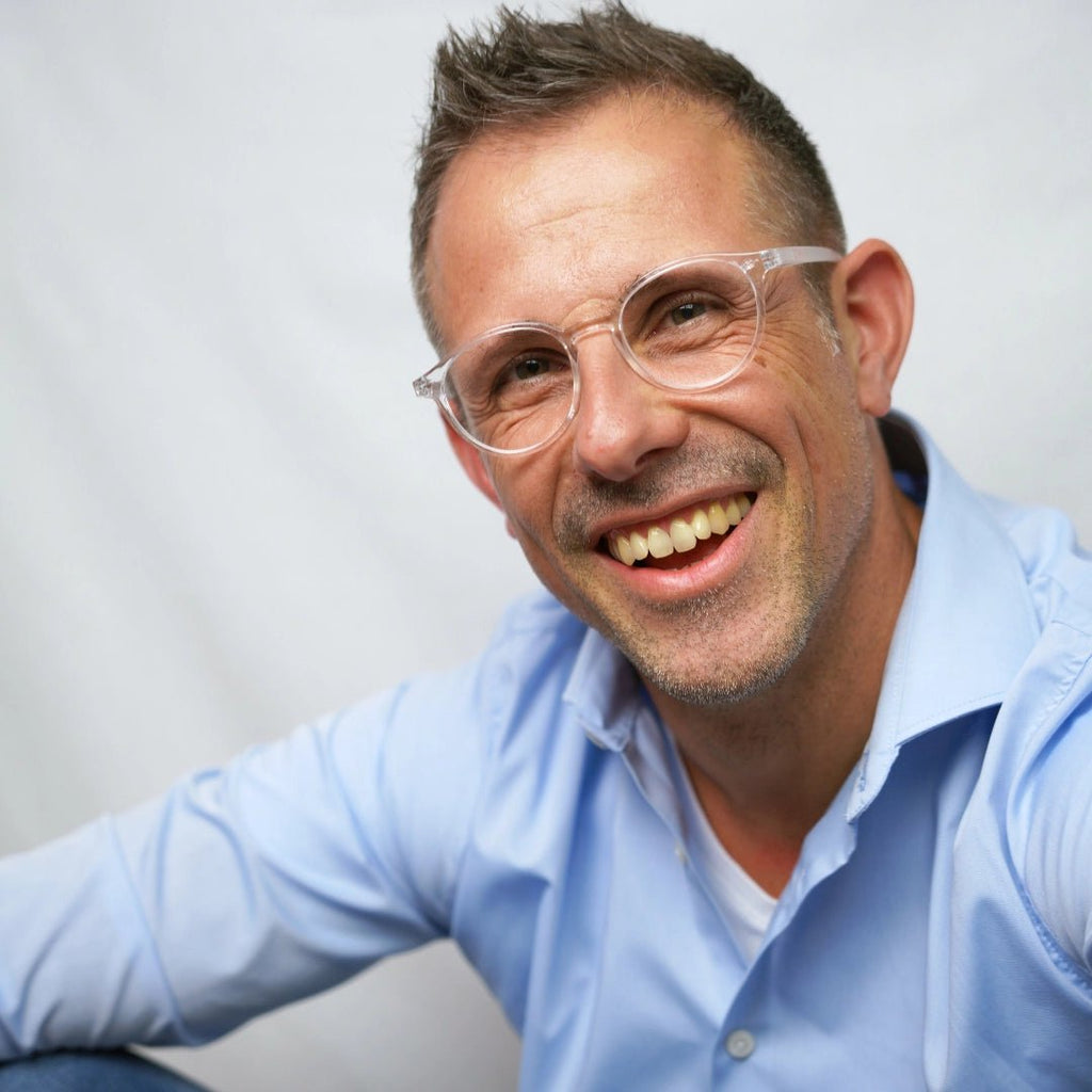 Klammeraffe No.12 reading glasses in crystal color with longer temples, worn by a man on a white background.
