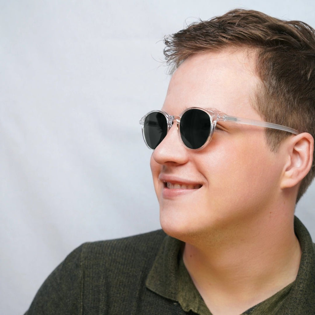 Klammeraffe No.12 sunglasses in crystal color with longer temples, worn by a man on a white background.