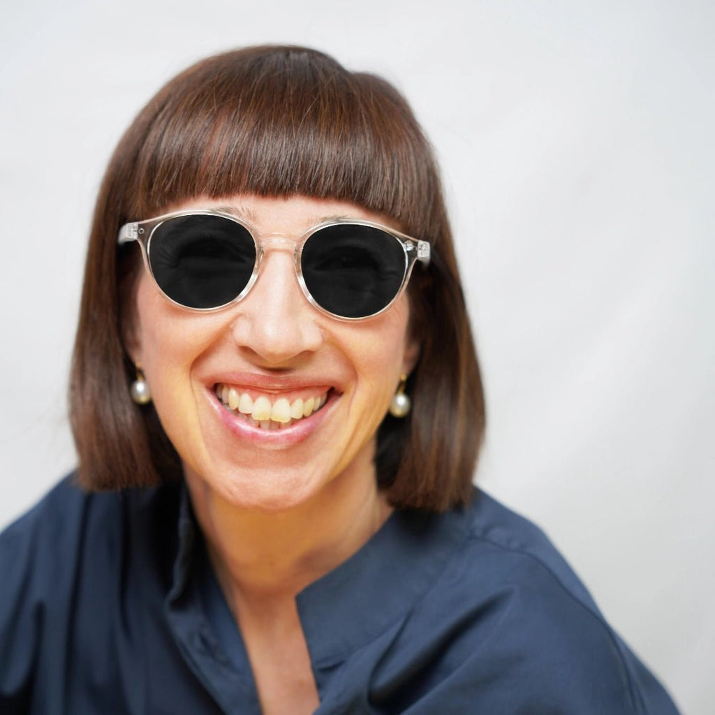 Klammeraffe No.12 sunglasses in crystal color with longer temples, worn by a woman on a white background.