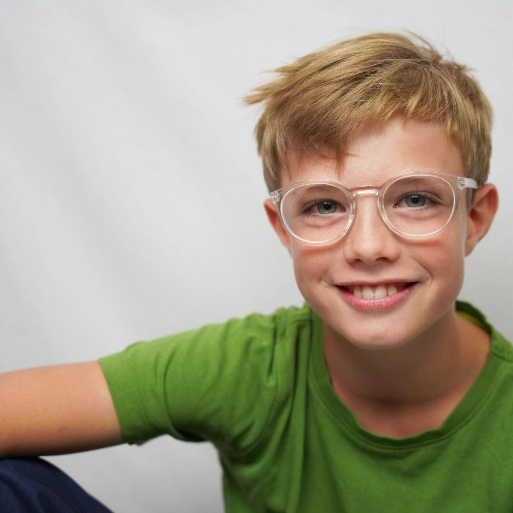 Klammeraffe No.13 blue light glasses in crystal color with longer temples, worn by a boy on a white background.