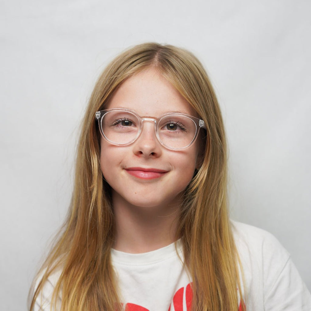 Klammeraffe No.13 blue light glasses in crystal color with longer temples, worn by a girl on a white background.