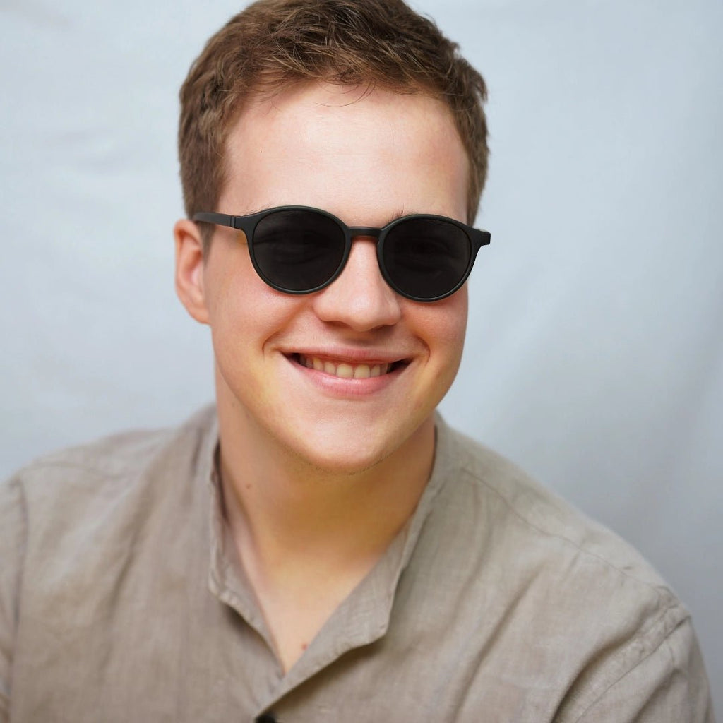 Klammeraffe No.12 sunglasses in black color with longer temples, worn by a man on a white background.